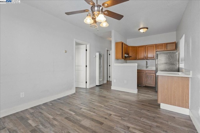 kitchen featuring black fridge, hardwood / wood-style flooring, sink, and ceiling fan