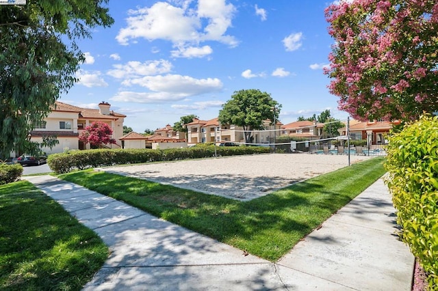 view of home's community with volleyball court and a yard