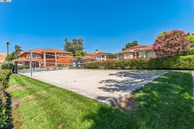 view of home's community with volleyball court and a yard