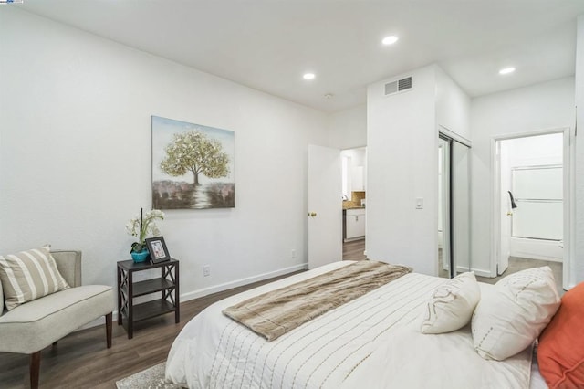 bedroom with dark wood-type flooring and a closet