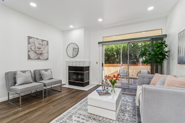 living room featuring a tile fireplace and hardwood / wood-style floors