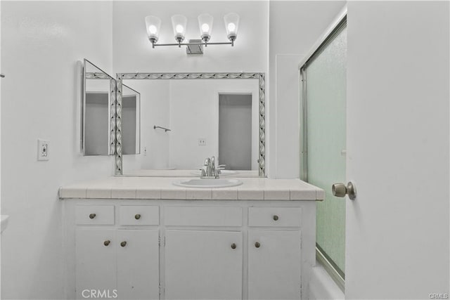 bathroom featuring enclosed tub / shower combo and vanity