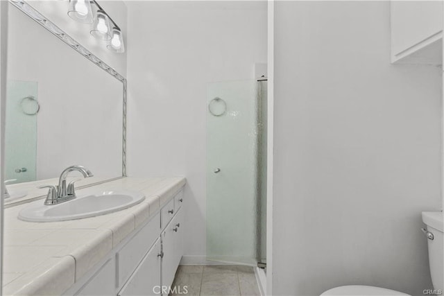 bathroom featuring toilet, a shower with shower door, tile patterned floors, and vanity