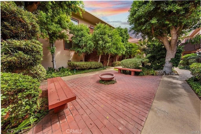 patio terrace at dusk featuring a fire pit