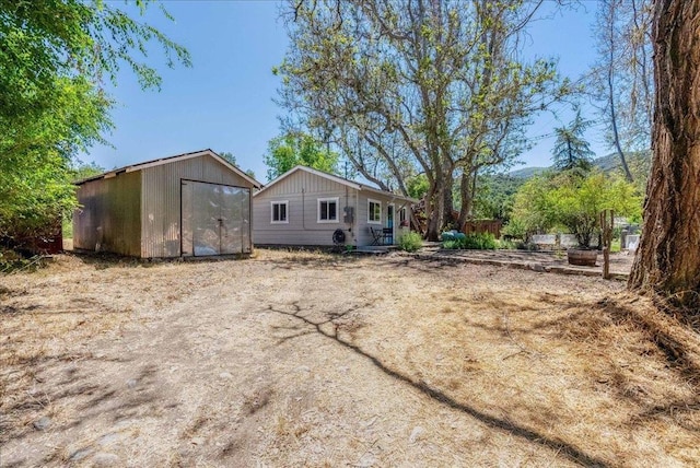 rear view of property with an outdoor structure