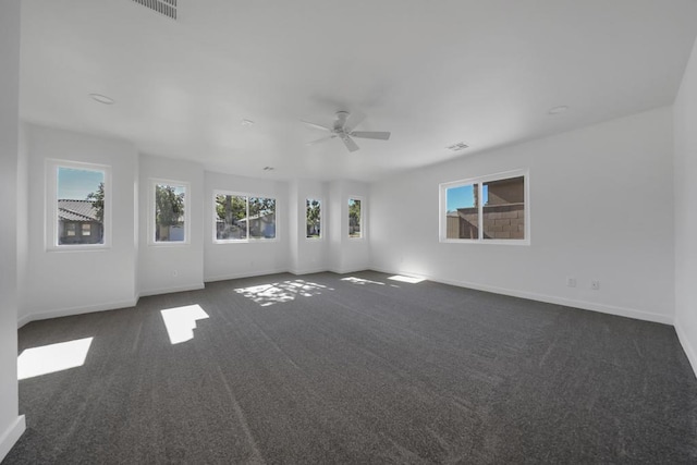 unfurnished room featuring ceiling fan and dark carpet