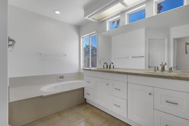 bathroom featuring vanity, tile patterned flooring, and a tub