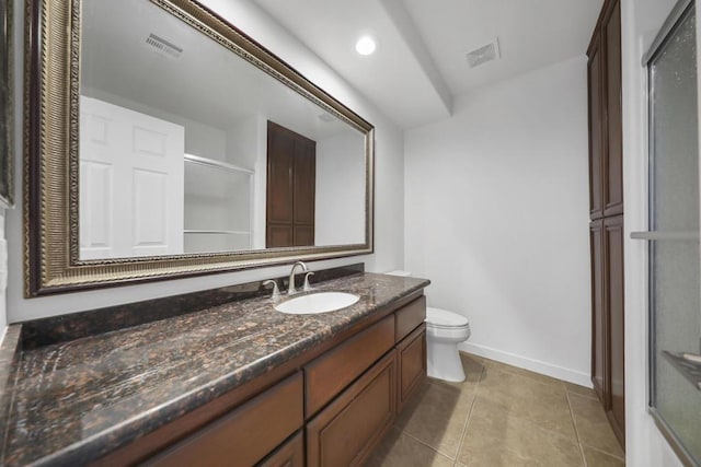 bathroom with a shower with door, vanity, tile patterned floors, and toilet