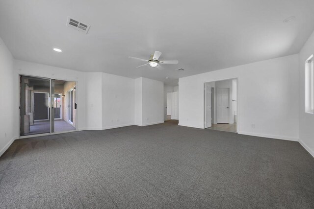 spare room with ceiling fan and dark colored carpet