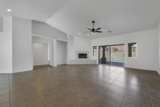 unfurnished living room with tile patterned flooring, ceiling fan, vaulted ceiling, and a fireplace