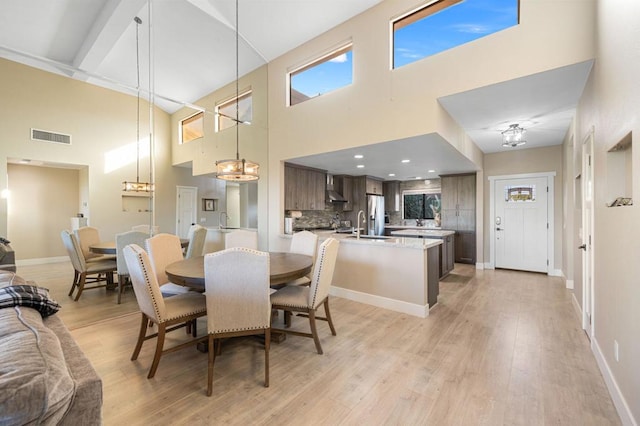 dining room with a high ceiling and light wood-type flooring