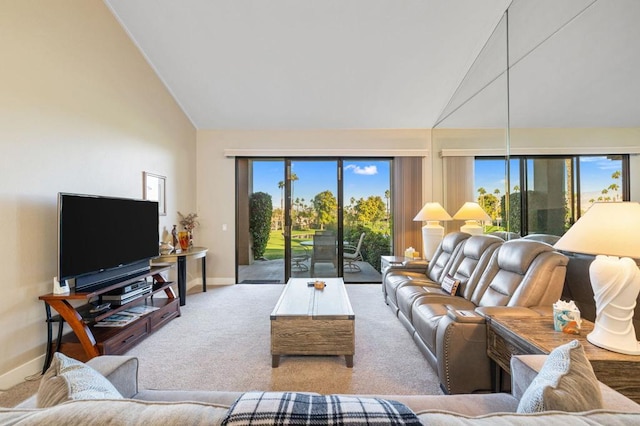 living room with high vaulted ceiling, plenty of natural light, and light colored carpet