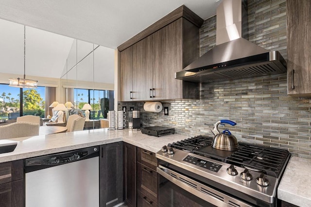 kitchen with stainless steel appliances, wall chimney range hood, backsplash, and dark brown cabinetry