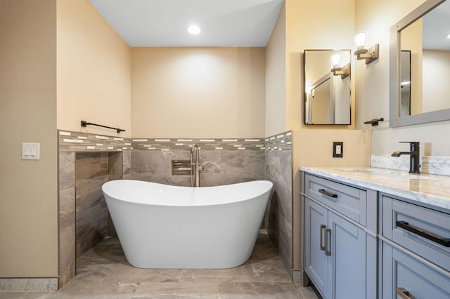 bathroom featuring tile walls, a washtub, and vanity