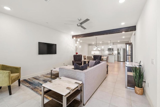 living room featuring ceiling fan with notable chandelier, beam ceiling, and light tile patterned floors