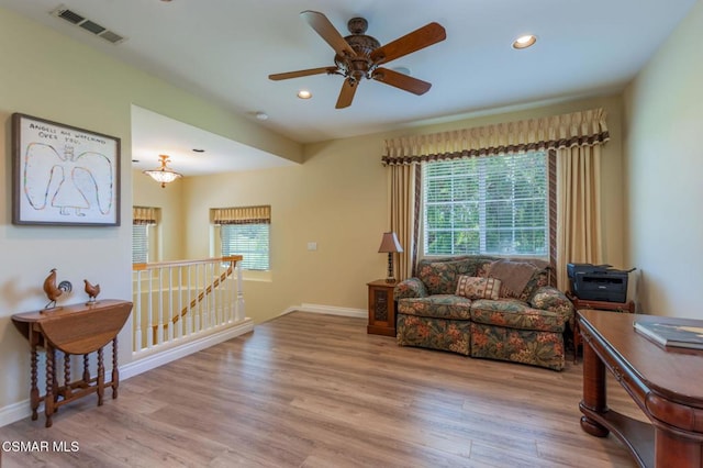 living area featuring light hardwood / wood-style floors and ceiling fan