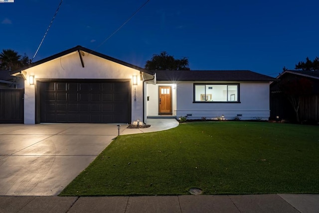 ranch-style home featuring a garage and a yard