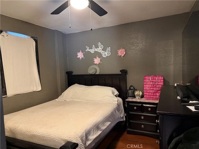 bedroom with ceiling fan and dark hardwood / wood-style flooring