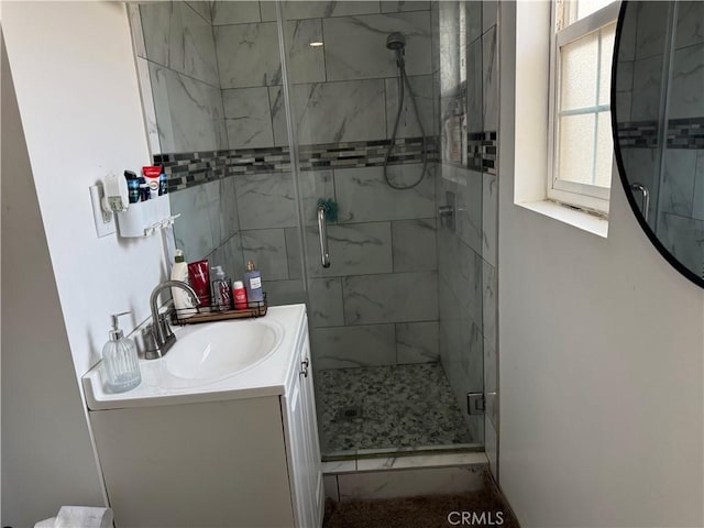 bathroom with vanity and a shower with door