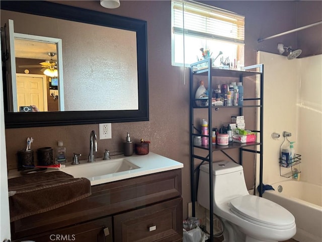 full bathroom featuring vanity, ceiling fan, washtub / shower combination, and toilet