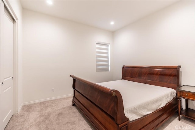 bedroom featuring light colored carpet and a closet