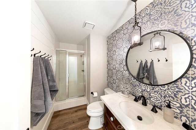 bathroom featuring walk in shower, hardwood / wood-style floors, vanity, and toilet