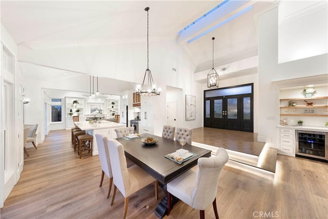 dining area featuring high vaulted ceiling, beverage cooler, light hardwood / wood-style floors, and beamed ceiling