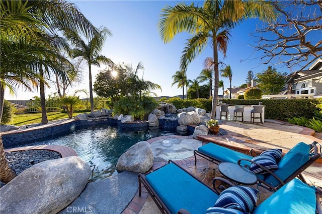 view of pool with exterior bar and a patio