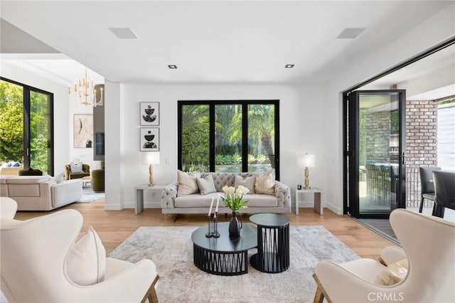 living room with light hardwood / wood-style flooring and a chandelier