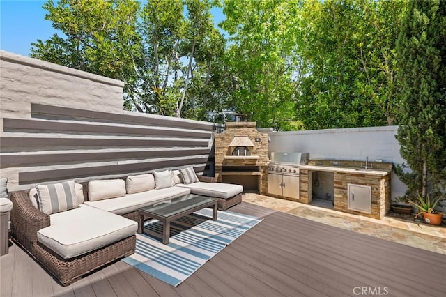 deck featuring sink, an outdoor kitchen, an outdoor living space, and area for grilling