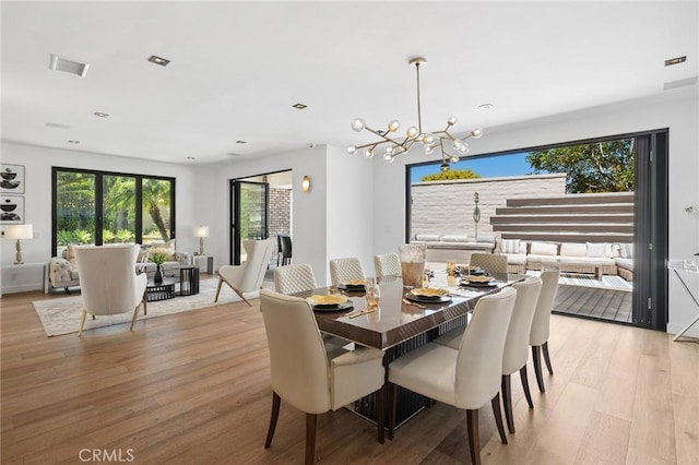 dining room with light hardwood / wood-style flooring and a chandelier