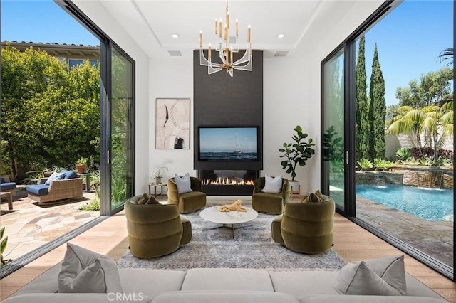 sunroom / solarium with a large fireplace, a healthy amount of sunlight, and an inviting chandelier