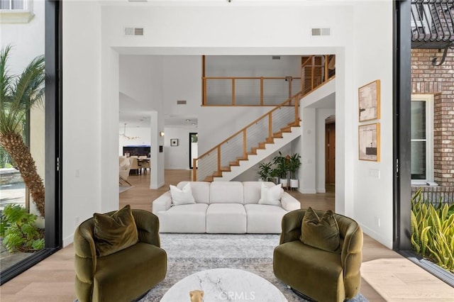 living room with a high ceiling and light wood-type flooring