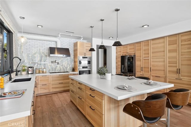 kitchen with stainless steel appliances, a center island, wall chimney exhaust hood, a kitchen breakfast bar, and hanging light fixtures