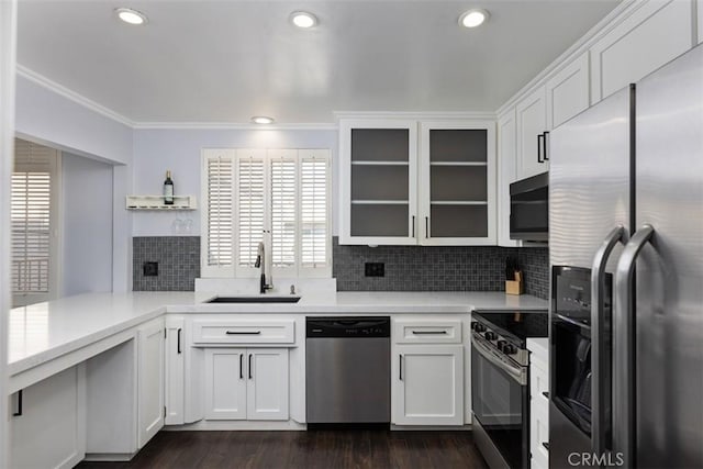 kitchen with sink, white cabinets, kitchen peninsula, dark hardwood / wood-style floors, and appliances with stainless steel finishes