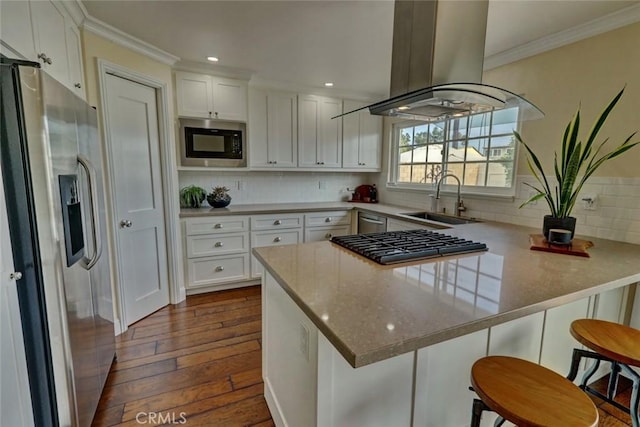 kitchen featuring sink, a kitchen breakfast bar, kitchen peninsula, stainless steel appliances, and white cabinets