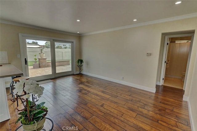 unfurnished living room with crown molding and dark hardwood / wood-style flooring