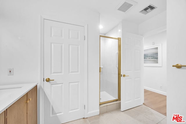 bathroom featuring vanity, tile patterned flooring, and a shower with door