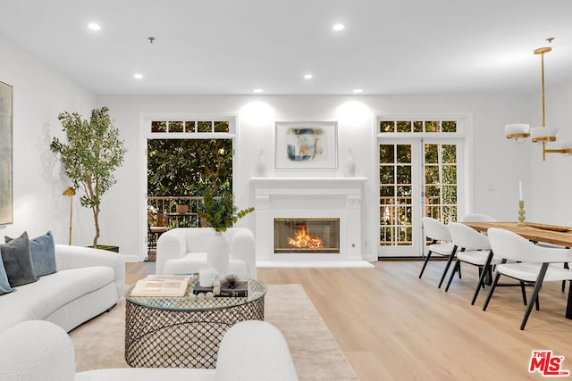 living room with an inviting chandelier and light wood-type flooring