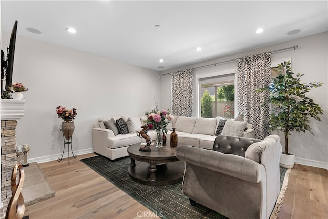 living room with a fireplace and light wood-type flooring