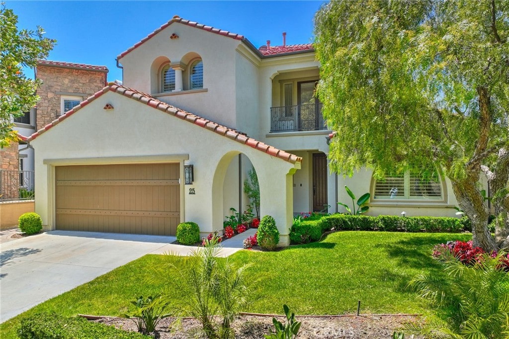 mediterranean / spanish-style house featuring a balcony and a front yard