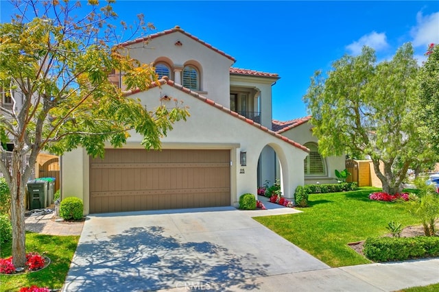 mediterranean / spanish home featuring a front yard, a balcony, and a garage