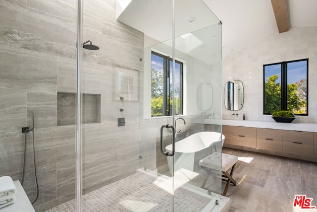 bathroom with tile walls, lofted ceiling with beams, independent shower and bath, and vanity