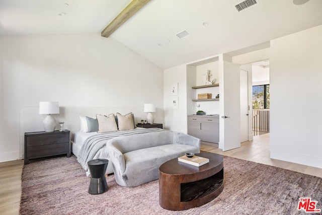 bedroom featuring light wood-type flooring and vaulted ceiling with beams