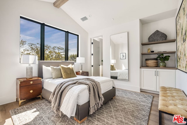 bedroom featuring dark hardwood / wood-style flooring and lofted ceiling with beams