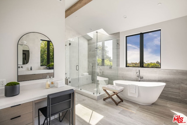 bathroom with tile walls, lofted ceiling with beams, independent shower and bath, and vanity