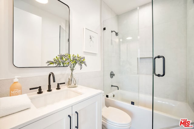 full bathroom featuring toilet, enclosed tub / shower combo, and vanity