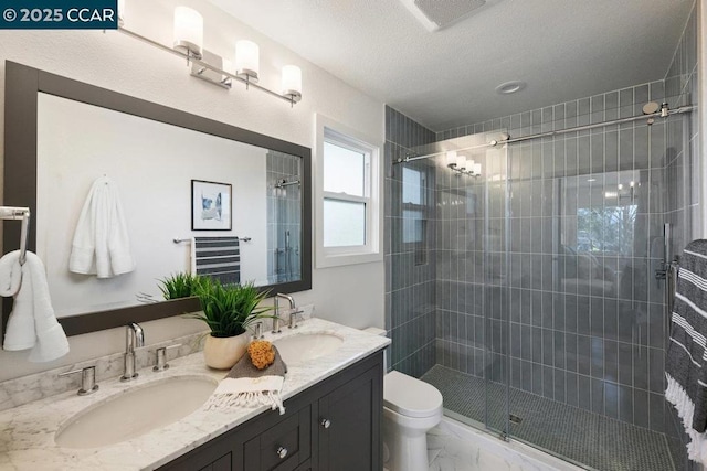 bathroom with toilet, vanity, and a shower with shower door