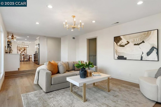 living room featuring a notable chandelier and light hardwood / wood-style flooring