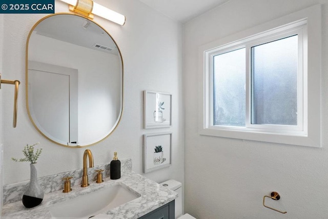 bathroom featuring toilet and vanity